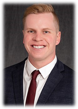 A person in a suit and tie Description automatically generated with medium confidence